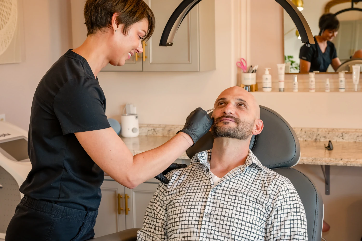 Jennifer Vergeer, a nurse practitioner, performs an aesthetic injection near a patient’s eye.