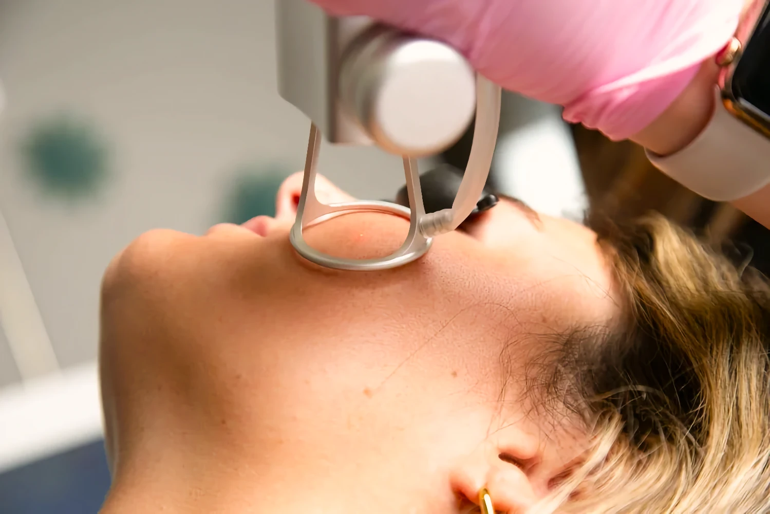 A provider applies a skin care treatment device to a patient’s cheek.