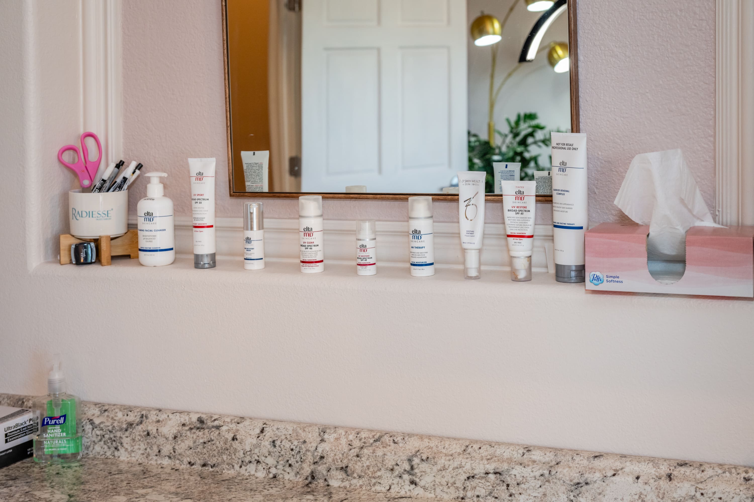 A bathroom counter with many different types of skin care products.