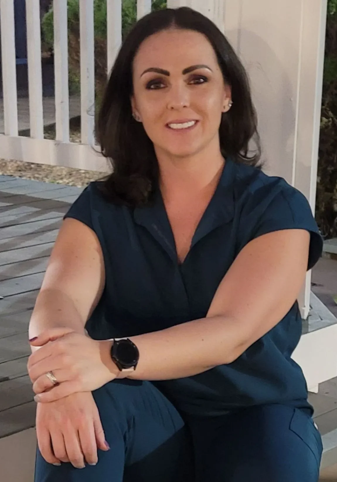 A woman sitting on the ground with her hands crossed.